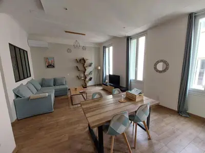 a living room with a table and a couch at Le Mistralet in Salon-de-Provence