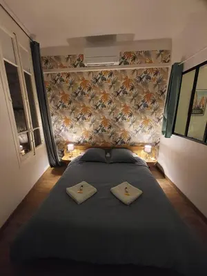 a bedroom with a large bed with two pillows on it at Le Mistralet in Salon-de-Provence