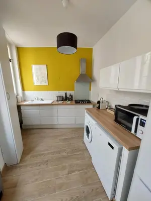 a kitchen with white cabinets and a washer at Le Mistralet in Salon-de-Provence