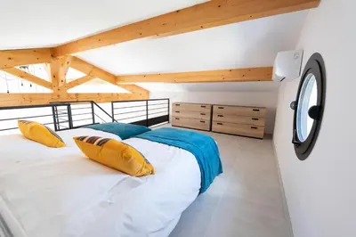 a bedroom with a large bed in a room with wooden ceilings at Maison Réglisse du MAS LOU CAPY in Salon-de-Provence