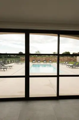 a view of a swimming pool from inside a building at Maison Réglisse du MAS LOU CAPY in Salon-de-Provence