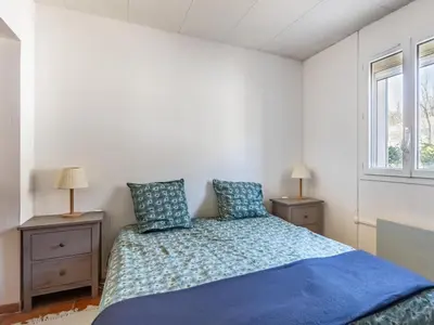 a bedroom with a bed with blue sheets and two night stands at Holiday Home La Campagne des Ocres by Interhome in Rustrel