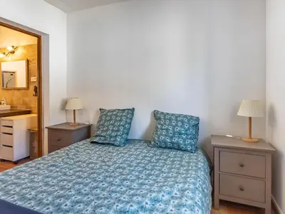 a bedroom with a bed and two night stands and a mirror at Holiday Home La Campagne des Ocres by Interhome in Rustrel