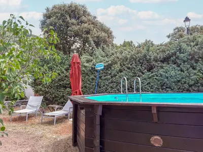 a swimming pool with an umbrella and two chairs and a table at Holiday Home La Campagne des Ocres by Interhome in Rustrel