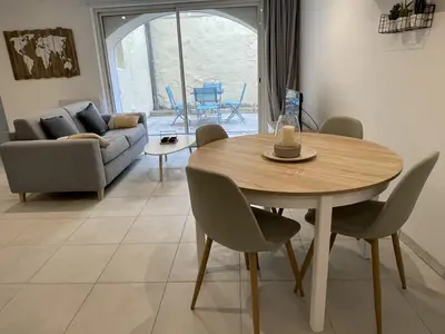 a dining room table and chairs in a living room at Appartement climatisé avec cour en centre ville in Carpentras