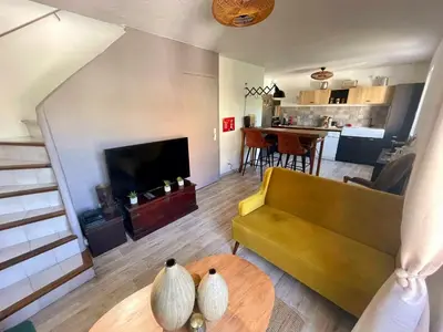 a living room with a couch and a table at Lumineux Duplex au coeur de l'Isle in LʼIsle-sur-la-Sorgue