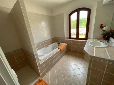 a bathroom with a tub and a sink at BASTIDE DU DEFENDS in Pertuis