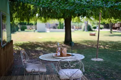 a table with two chairs and a table with drinks on it at Mas des muses in LʼIsle-sur-la-Sorgue