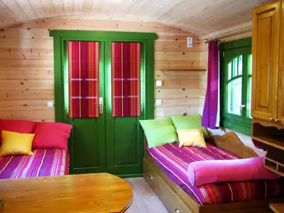 two beds in a room with green and pink at La Roulotte des Oliviers in Saint-Pierre-de-Vassols