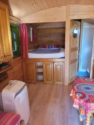 a room with a bed in a wooden cabin at La Roulotte des Oliviers in Saint-Pierre-de-Vassols