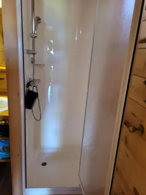a shower with a glass door in a bathroom at La Roulotte des Oliviers in Saint-Pierre-de-Vassols
