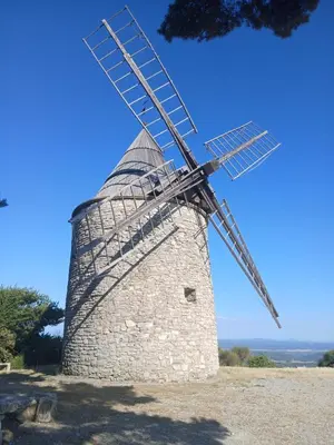 a stone windmill sitting on top of a field at Maison jaune in Villemus
