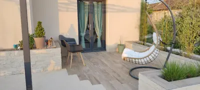 a patio with a chair and a door with plants at Villa 3 ch, 6/8p, avec piscine Luberon, Provence in Saignon