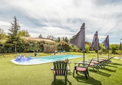 a group of chairs and umbrellas in front of a swimming pool at Villa 3 ch, 6/8p, avec piscine Luberon, Provence in Saignon