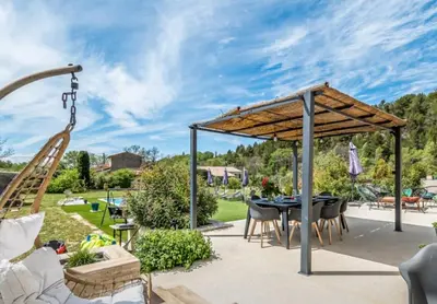 a patio with a table and chairs and a swing at Villa 3 ch, 6/8p, avec piscine Luberon, Provence in Saignon