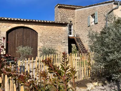 a house with a wooden fence in front of it at MAS-Calou in Coustellet