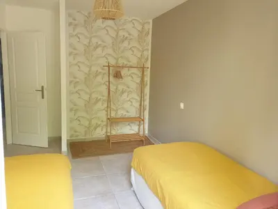 two beds in a room with yellow sheets at Une maison en Provence in Pierrevert