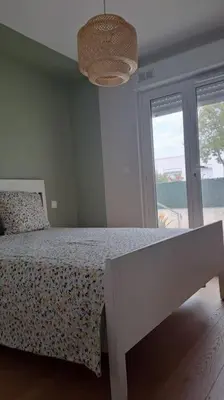 a bedroom with a bed and a large window at Maison paisible et ensoleillée in Avignon