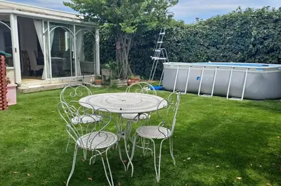 a table and chairs in a yard with a pool at Maison paisible et ensoleillée in Avignon