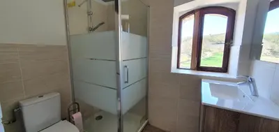 a bathroom with a toilet and a sink and a window at Appartement 3P Lubéron in Viens