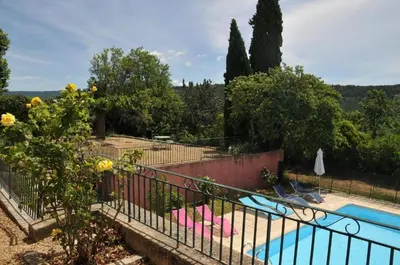 a swimming pool in a garden with a fence at Appartement 3P Lubéron in Viens