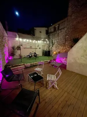 a patio with chairs and lights at night at Appartement Love room avec jacuzzi et hammam privatisé Lieu insolite en amoureux Spa détente assurée avec de doux massages en options sur demande in Orgon