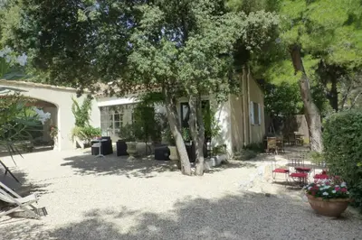 a yard with tables and chairs and trees at Property with panoramic views in Cabrières-dʼAvignon