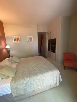 a bedroom with a large bed and a red chair at Property with panoramic views in Cabrières-dʼAvignon