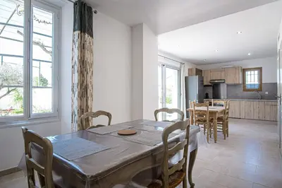 a kitchen and dining room with a table and chairs at Maison avec jardin proche du centre-ville Isle-sur-la-Sorgue in LʼIsle-sur-la-Sorgue