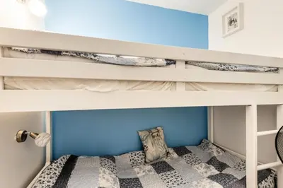 a bunk bed in a kids room with a blue wall at Village Pont Royal en Provence - maeva Home - Appartement décoré avec goût et climatisé 2 pièces 5 personnes - Prestige - super Home MAE-1144 in Mallemort