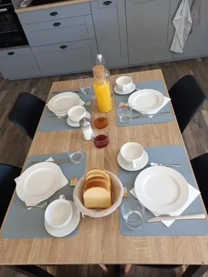 a table with white plates and bread and a bottle of orange juice at A Ventoux Yourte in Monieux