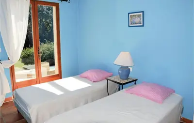 two beds in a blue room with a window at Amazing Home In Roussillon With Wifi in Roussillon