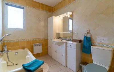 a bathroom with a tub and a toilet and a sink at Beautiful Home In Lauris With Wifi in Lauris