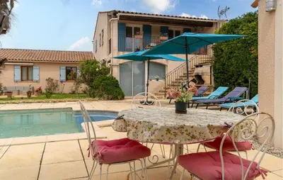 a table with an umbrella and chairs next to a pool at Beautiful Home In Lauris With Wifi in Lauris