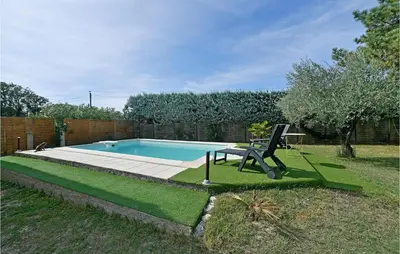 a pool with a chair and a table in a yard at 3 Bedroom Nice Home In Mazan in Mazan