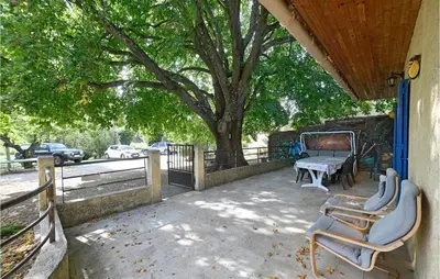a patio with chairs and a table and a tree at 3 Bedroom Nice Home In Mazan in Mazan