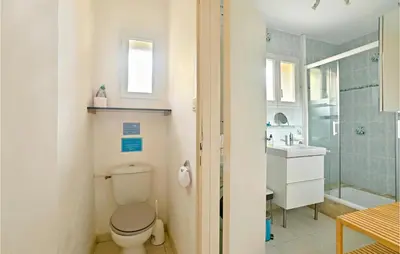 a bathroom with a toilet and a sink at 3 Bedroom Nice Home In Mazan in Mazan