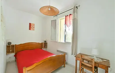 a bedroom with a bed and a desk and a window at 3 Bedroom Nice Home In Mazan in Mazan