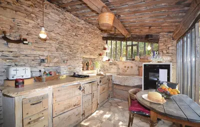a kitchen with a table and a stone wall at 1 Bedroom Beautiful Home In Saignon in Saignon