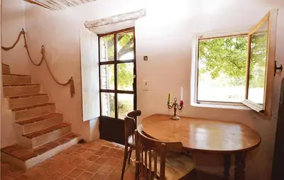 a dining room with a wooden table and a window at 1 Bedroom Beautiful Home In Saignon in Saignon