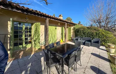a table and chairs under a pergola in a yard at Mas Mirasol in Gargas