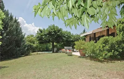 a yard with a building and a bench and trees at Mas Mirasol in Gargas