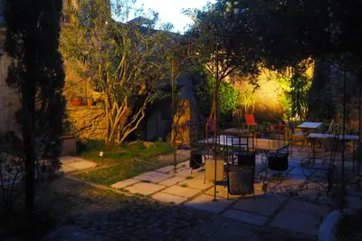 a garden at night with a table and chairs at Chambres d'Hôtes Le relais des marmottes en Luberon in Lagnes