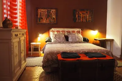 a bedroom with a large bed and a dresser at Chambres d'Hôtes Le relais des marmottes en Luberon in Lagnes