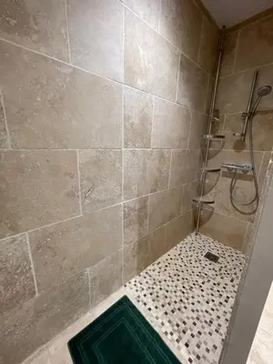 a bathroom with a shower with a tiled wall at Petite maison près du centre in LʼIsle-sur-la-Sorgue