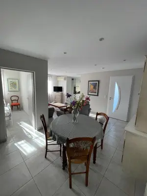 a dining room with a table and chairs and a living room at Petite maison près du centre in LʼIsle-sur-la-Sorgue