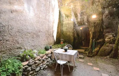 a table and chairs in a room with a stone wall at 3 Bedroom Nice Home In Bonnieux in Bonnieux