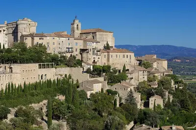 a large castle on top of a mountain at Apartments - Experience of PROVENCE in Gordes