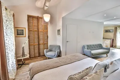 a bedroom with a bed and two blue chairs at Apartments - Experience of PROVENCE in Gordes