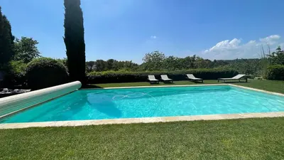 a swimming pool in the grass with two chairs next to it at Exclusif Appart piscine chauffée de luxe 10 min centre AixenPc Belvoir SISSI in Aix-en-Provence